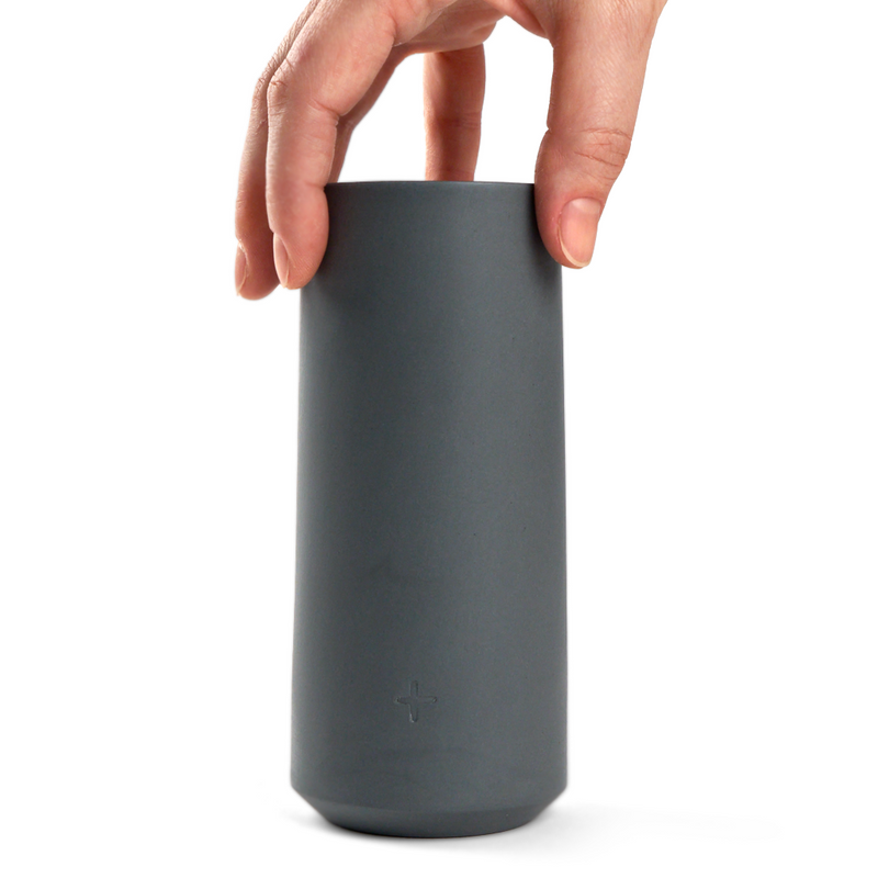 hand holding a dark grey porcelain highball glass