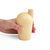 A hand holding a yellow carafe with a cork stopper.