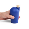 A hand holding a dark blue carafe with a cork stopper.