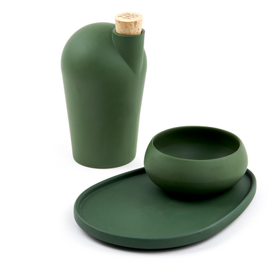 A green carafe next to a green pairing plate and matching green copita.