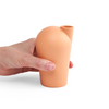 A side view of a hand holding a porcelain orange carafe.