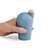 A hand holding a light sea green colored carafe with a cork stopper.
