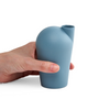 A side view of a hand holding a porcelain light teal carafe.