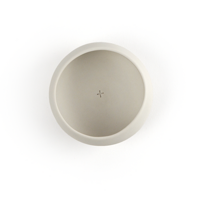Top shot of a white porcelain copita with a small cross stamped on the inside