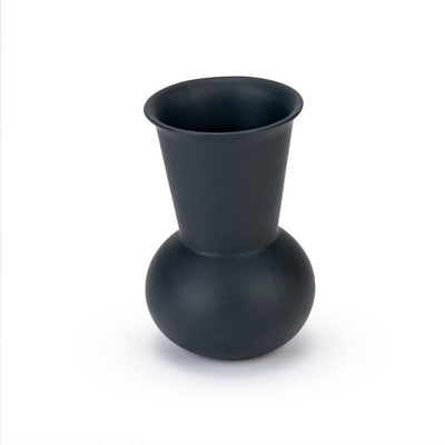 A three quarter view of a black charcoal  tequila sipping glass