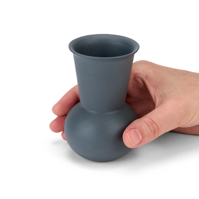 A hand holding a Dark Grey TUYO tequila sipping glass