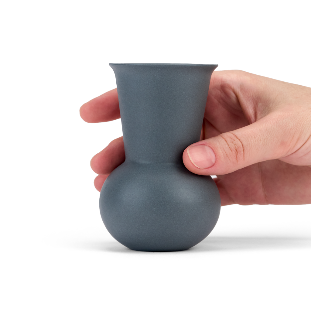 A hand holding a Dark Grey colored TUYO tequila sipping glass