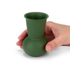 A hand holding a Green TUYO tequila sipping glass