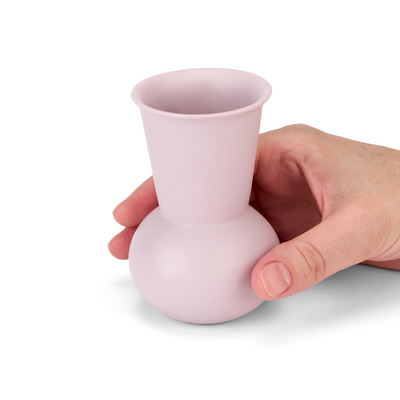 A hand holding a Lavender TUYO tequila sipping glass