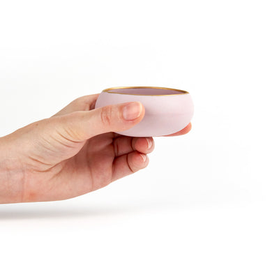 Hand holding one lavender and gold porcelain copita